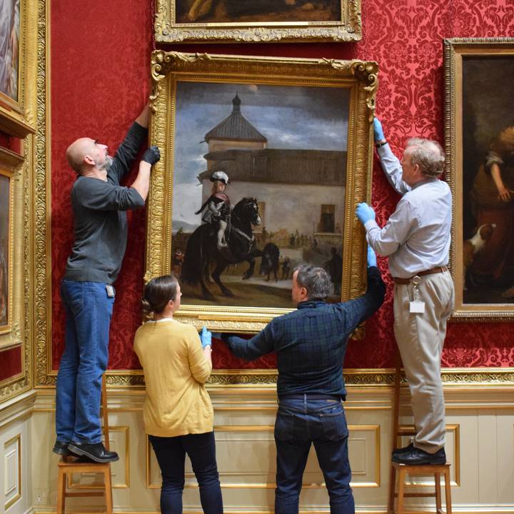 Figures removing a painting from gallery wall