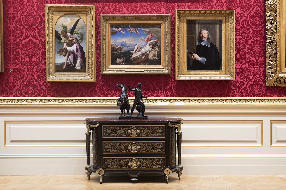 Three paintings and cabinet with figure statue on in museum interior