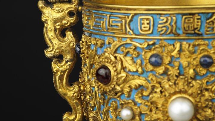 Detail of side of gold cup and dragon shaped handle